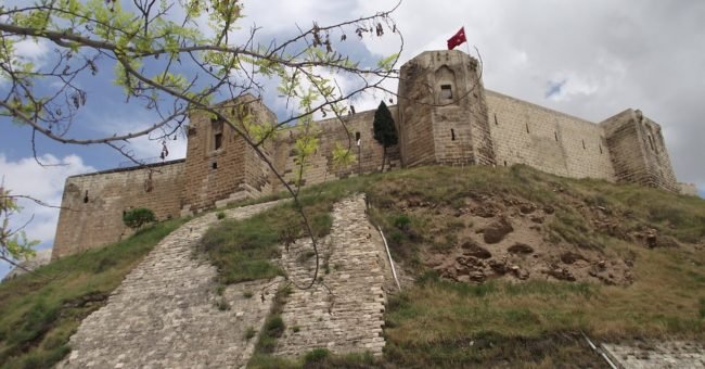 Historic Gaziantep Castle in Turkey, ancient stone fortress on a hill with Turkish flag, popular tourist attraction and cultural landmark in Gaziantep