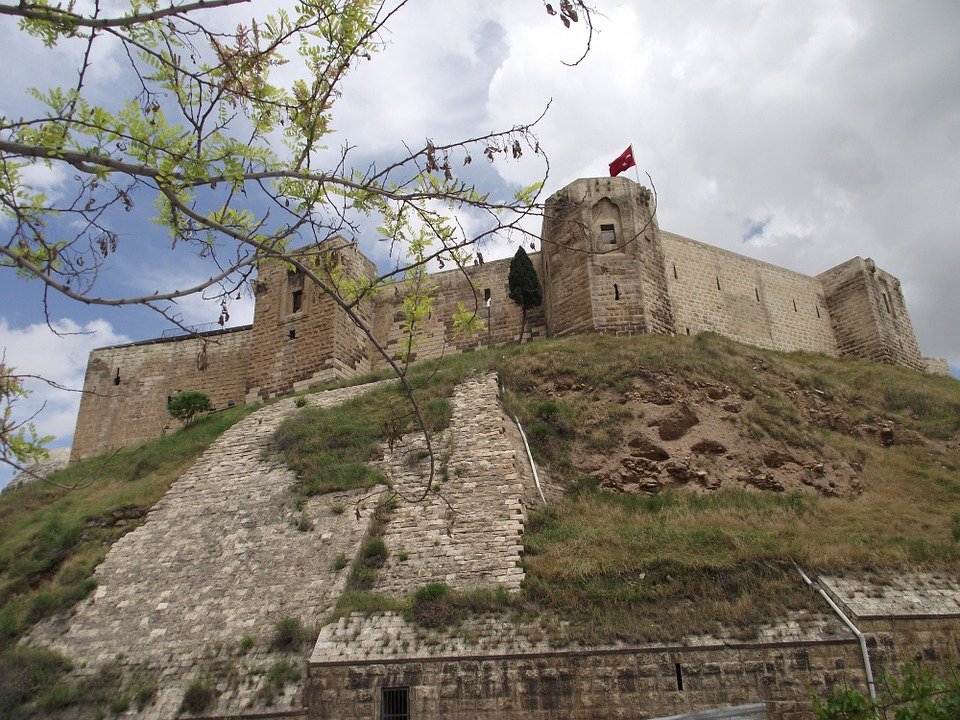 Historic Gaziantep Castle in Turkey, ancient stone fortress on a hill with Turkish flag, popular tourist attraction and cultural landmark in Gaziantep