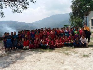 Human Harmony Nepal women’s empowerment program in Kagatigaun, Nepal, with local women and a volunteer gathered outdoors in the mountains.