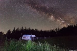 A camper at Yablanitsa Balkan huts in Bulgaria with the milky way as background in the starry night sky