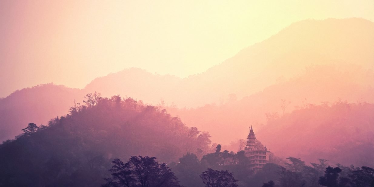 Sunset view of Rishikesh temple and Himalaya mountains in Uttarakhand, India.
