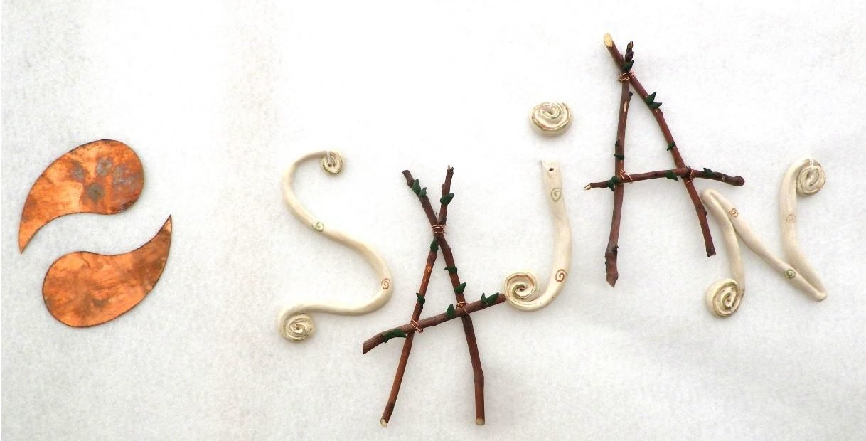 Sajan logo made from twigs, clay coils and copper leaves, representing the Sajan sustainability and permaculture volunteering project in Slovenia.