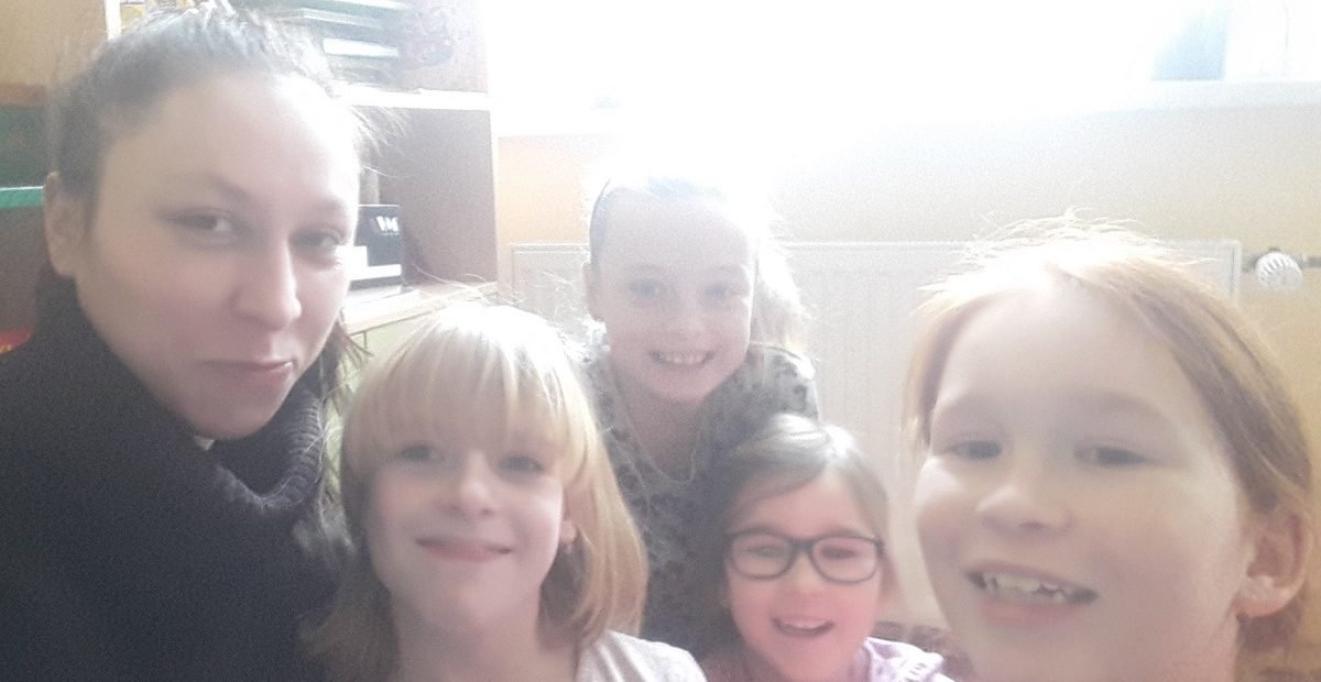 Volunteer English teacher with a small group of smiling children at an English summer camp in Třemošná near Pilsen, Czech Republic