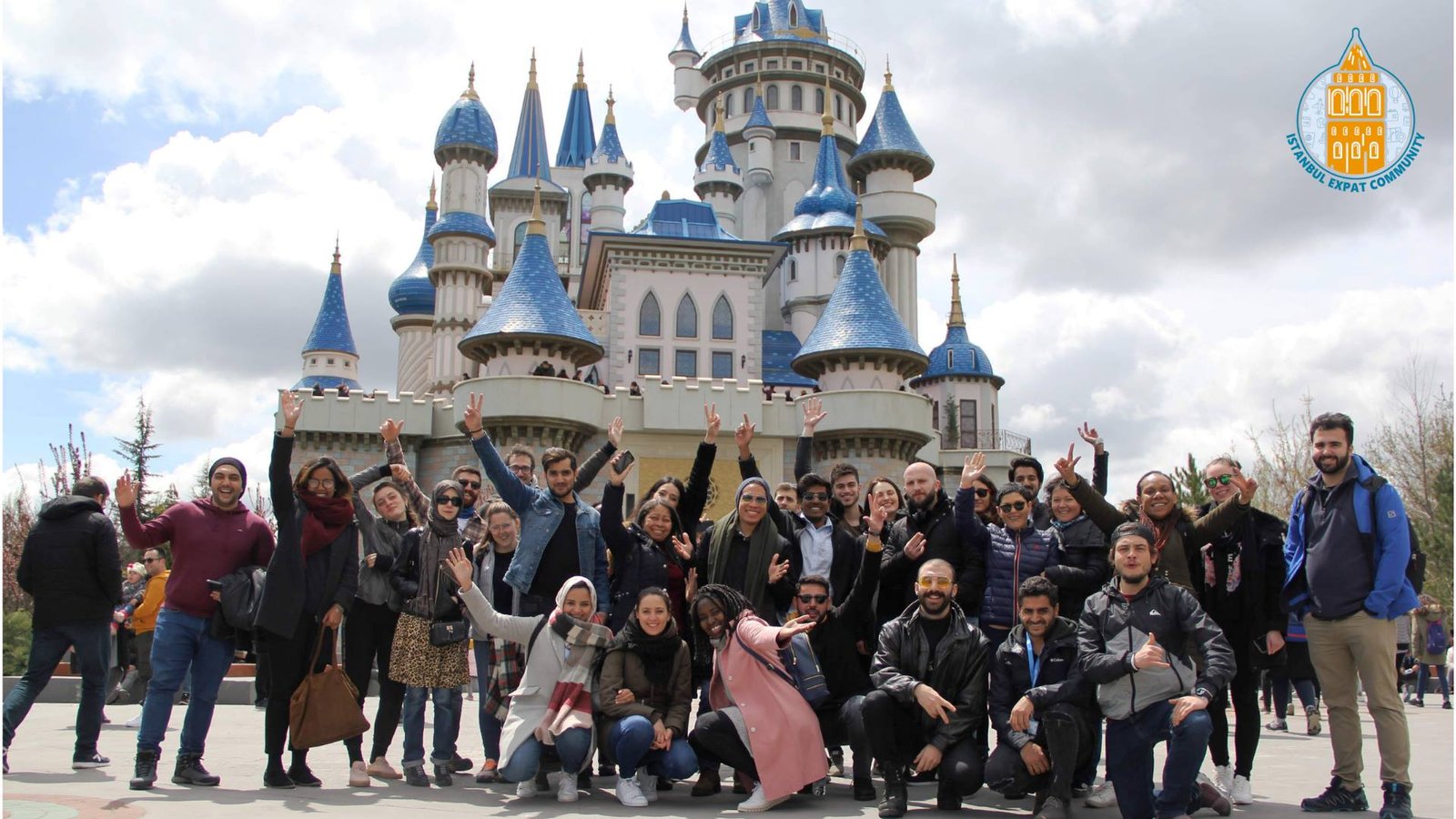 Group of Istanbul Expat Community volunteers and friends posing in front of a fairytale-style castle during a social event in Turkey, part of Istanbul Expat Community volunteering activities.
