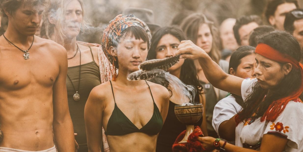 Indigenous smudging ceremony at Tribal Gathering Panama with multicultural participants in traditional spiritual ritual.