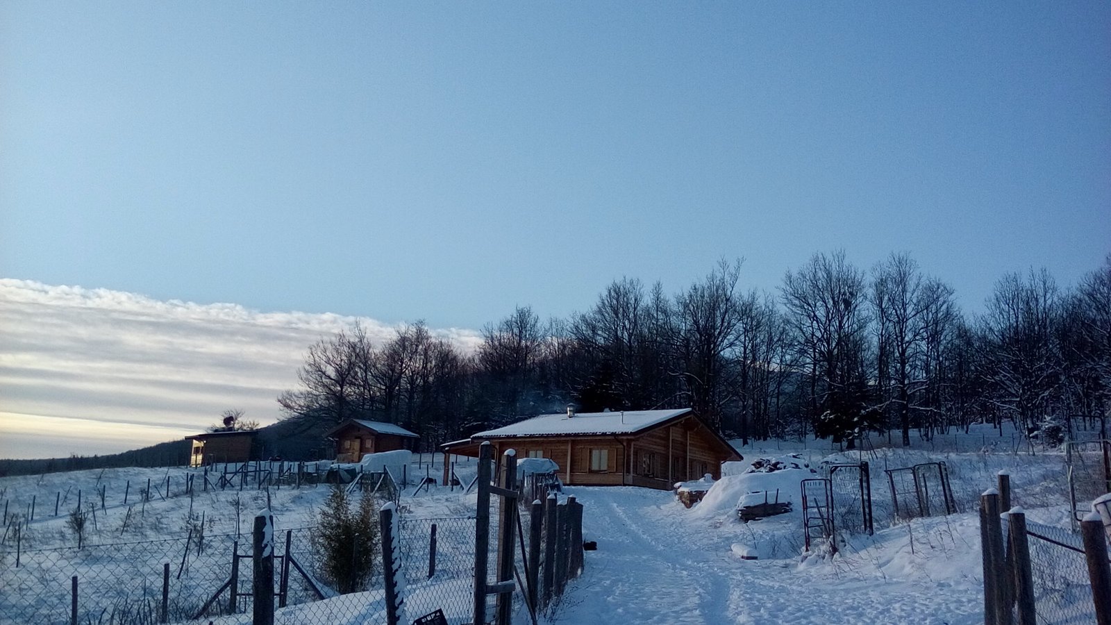 Snowy wooden house and fenced land in the Lucano Apennines, Basilicata, Italy, part of a self-sufficient volunteer project and hospitality exchange for people interested in volunteering, off grid and alternative lifestyles.