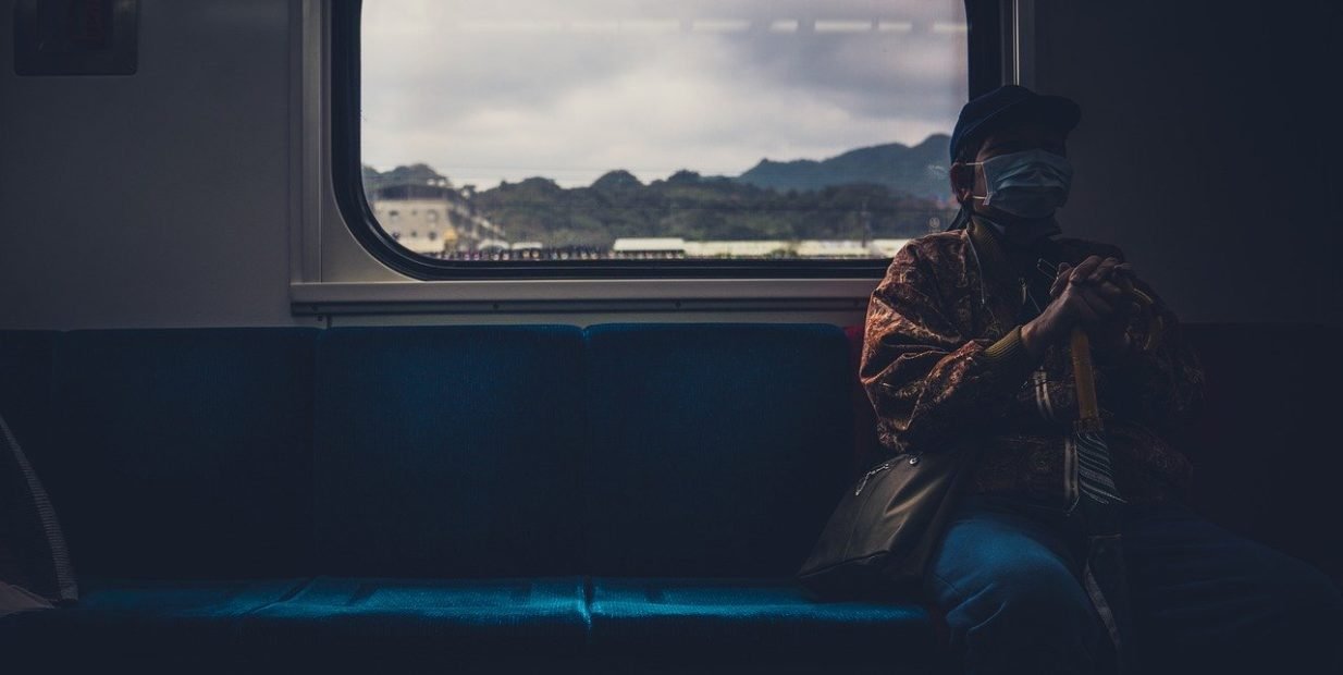Traveler looking out of a train window, representing support networks for people living and traveling on the road.
