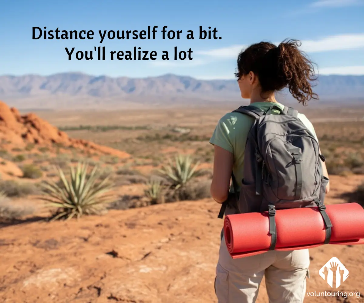 Female hiker with a gray backpack and red sleeping mat looking out over a desert valley with mountains in the distance. Quote reads, “Distance yourself for a bit. You’ll realize a lot.”