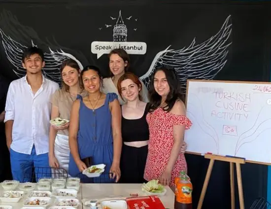 Group of young international volunteers at Speak in Istanbul participating in a Turkish cuisine activity, promoting cultural exchange and language learning in Turkey.