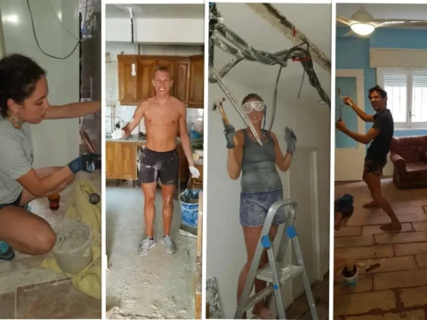 Volunteers smiling and working together on a home renovation project, painting walls, plastering, and handling construction tasks indoors in Madrid, Spain. The friendly and hands-on environment highlights teamwork and skill-sharing as part of a volunteer exchange experience.
