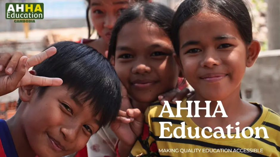 Group of Cambodian children smiling and posing in front of the camera, with the AHHA Education Cambodia logo and slogan "Making quality education accessible."