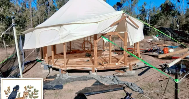 Timber-framed yurt with white canvas cover under construction at Jah Wa Le off-grid eco retreat in the forests of Durong, Queensland, Australia.