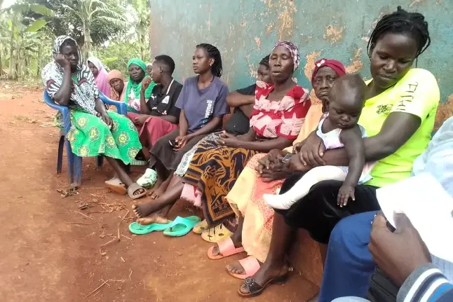 Mothers and Children Uganda women’s group meeting in Bugembe, Jinja as a mother holds her baby during a community support session.