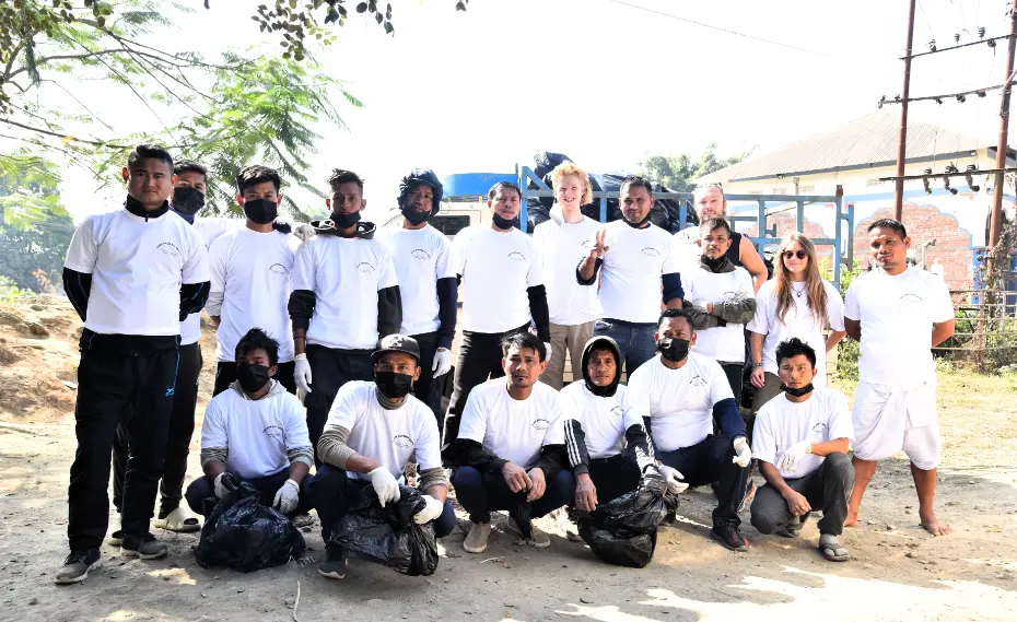 Volunteer in Manipur India at Langon Sanglen: group of local residents and international volunteers in white shirts after a community cleanup near Imphal.