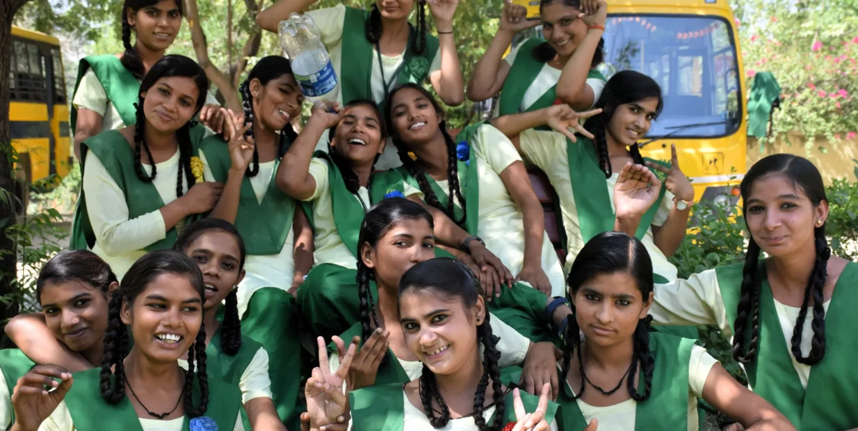 Volunteer opportunity in rural India with smiling schoolgirls in green uniforms at a girls’ school in Anupshahr, Uttar Pradesh