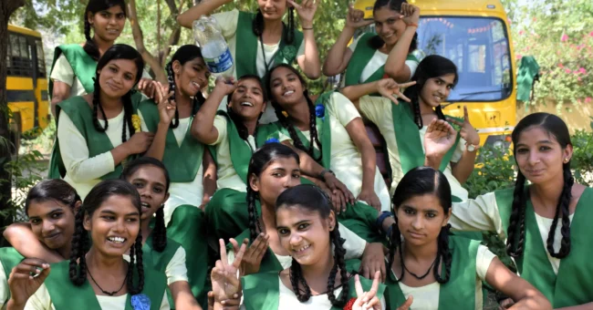 Volunteer opportunity in rural India with smiling schoolgirls in green uniforms at a girls’ school in Anupshahr, Uttar Pradesh
