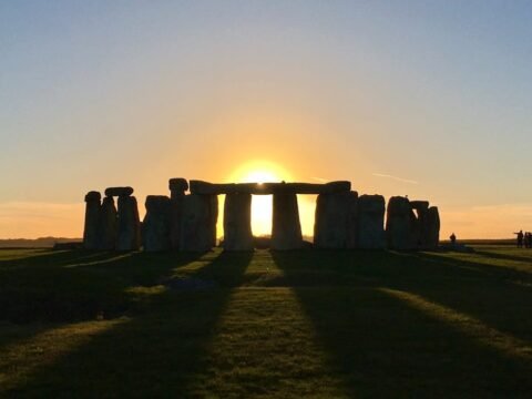 Stonehenge at sunrise on Salisbury Plain, with the low sun aligned through the stone circle, showing the link between Stonehenge and the solstice sky in England.