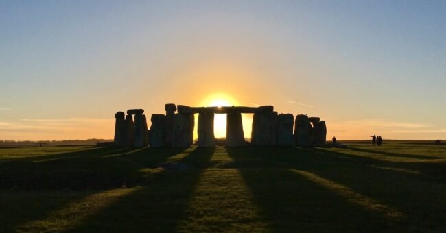 Stonehenge at sunrise on Salisbury Plain, with the low sun aligned through the stone circle, showing the link between Stonehenge and the solstice sky in England.