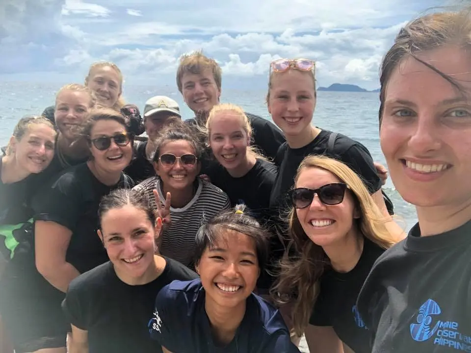 Group photo of Marine Conservation Philippines volunteers and team members smiling together by the coast in Negros Oriental