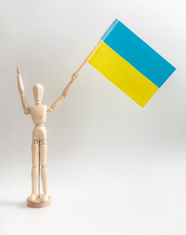 Wooden mannequin holding a Ukraine flag representing volunteer projects in Ukraine