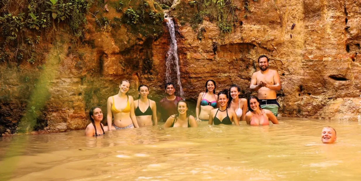 Volunteers enjoying a natural jungle pool and small waterfall at Aquicuana Reserve, Bolivia, during a digital marketing and eco-retreat volunteer stay with Sustainable Bolivia.