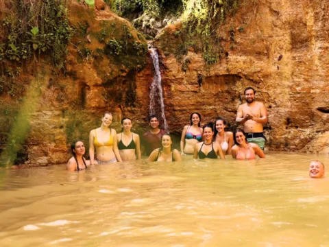 Volunteers enjoying a natural jungle pool and small waterfall at Aquicuana Reserve, Bolivia, during a digital marketing and eco-retreat volunteer stay with Sustainable Bolivia.
