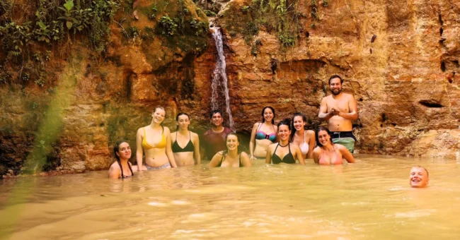 Volunteers enjoying a natural jungle pool and small waterfall at Aquicuana Reserve, Bolivia, during a digital marketing and eco-retreat volunteer stay with Sustainable Bolivia.