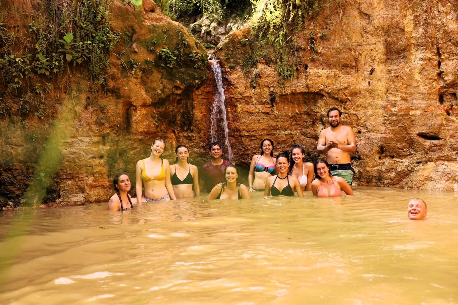 Volunteers enjoying a natural jungle pool and small waterfall at Aquicuana Reserve, Bolivia, during a digital marketing and eco-retreat volunteer stay with Sustainable Bolivia.