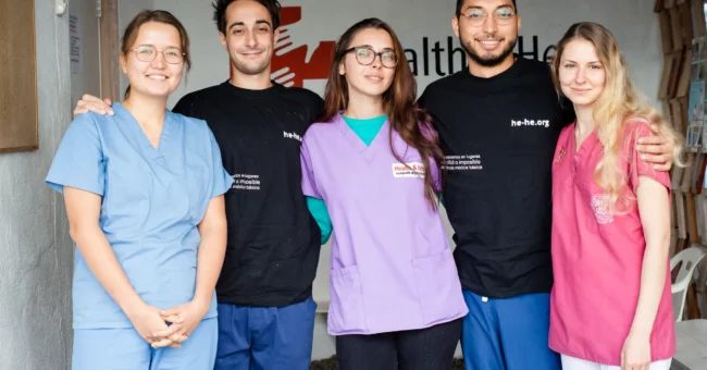 Health & Help medical staff and volunteers in scrubs at a rural healthcare clinic in Guatemala, supporting community medical care in Totonicapán.