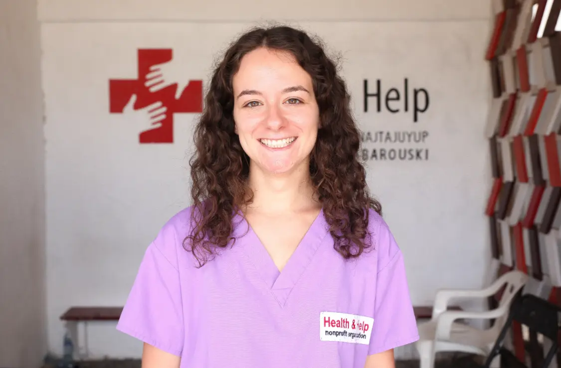 Health & Help medical volunteer in purple scrubs at a rural healthcare clinic in Guatemala, supporting community medical care in Totonicapán.
