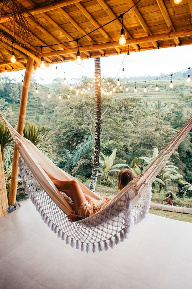 Traveler relaxing in a hammock with a tropical view after a volunteer stay, representing the moment to reflect and leave honest feedback about the experience.