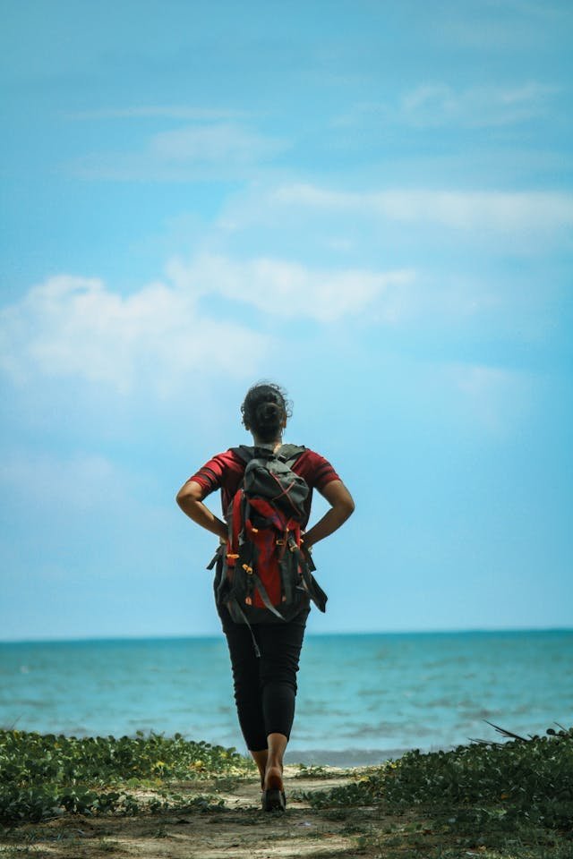  Backpacker walking toward the sea, representing independent travel websites and slow travel in the age of artificial intelligence search. 