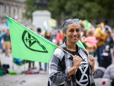 Climate activist holding an Extinction Rebellion flag during an XR protest.