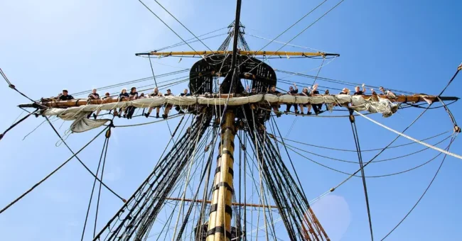 Volunteers working high in the rigging of the Götheborg wooden ship in Gothenburg, Sweden, during a ship volunteering opportunity.