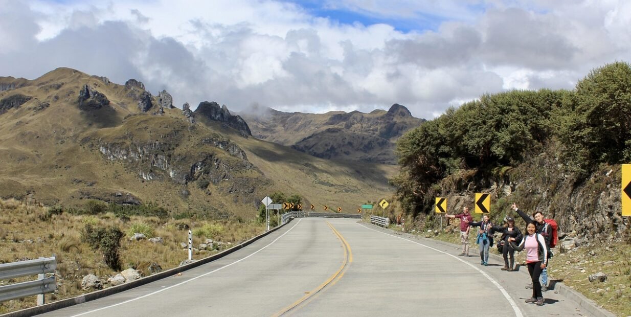 Travellers hitchhiking on a mountain road, image connected to Hitchgathering, hitchhiking communities, slow travel and alternative travel in Europe.