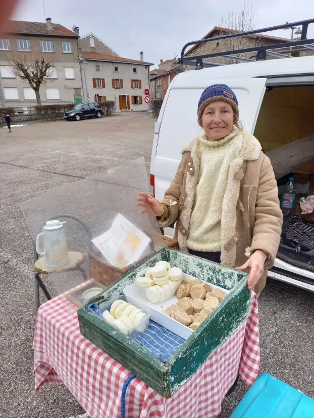 Cheese producer displaying handmade goat cheese at a local market near the volunteer farm in Ardèche, France
