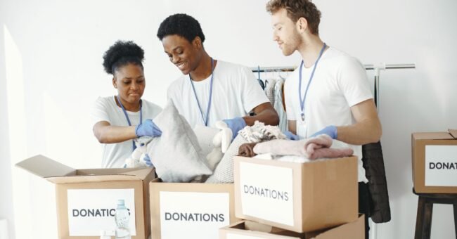 Volunteers managing boxes and donations for nonprofit fundraising Lo preferisco a un ALT con l’exact keyphrase intera perché descrive realmente la f