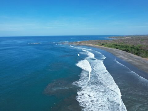Aerial view of the Pacific coastline near Marbella, Guanacaste, Costa Rica, with waves breaking along the beach.