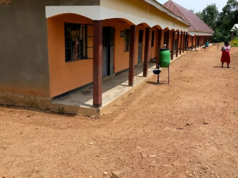Covered walkway and school buildings at Kayenje Church of Uganda Primary School in Butambala, a rural work exchange and teaching support location.