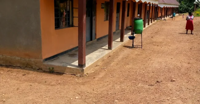 Covered walkway and school buildings at Kayenje Church of Uganda Primary School in Butambala, a rural work exchange and teaching support location.