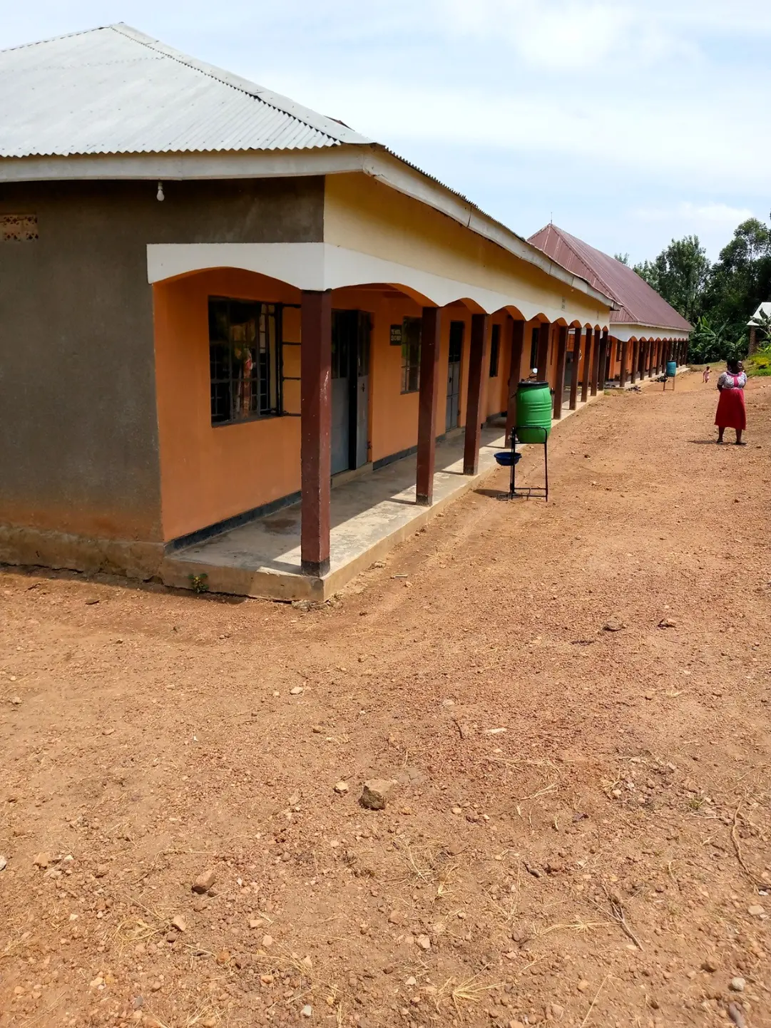 Covered walkway and school buildings at Kayenje Church of Uganda Primary School in Butambala, a rural work exchange and teaching support location.