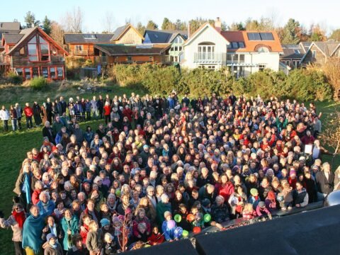 People gathered in front of homes at Findhorn Ecovillage in Scotland.
