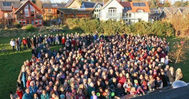People gathered in front of homes at Findhorn Ecovillage in Scotland.