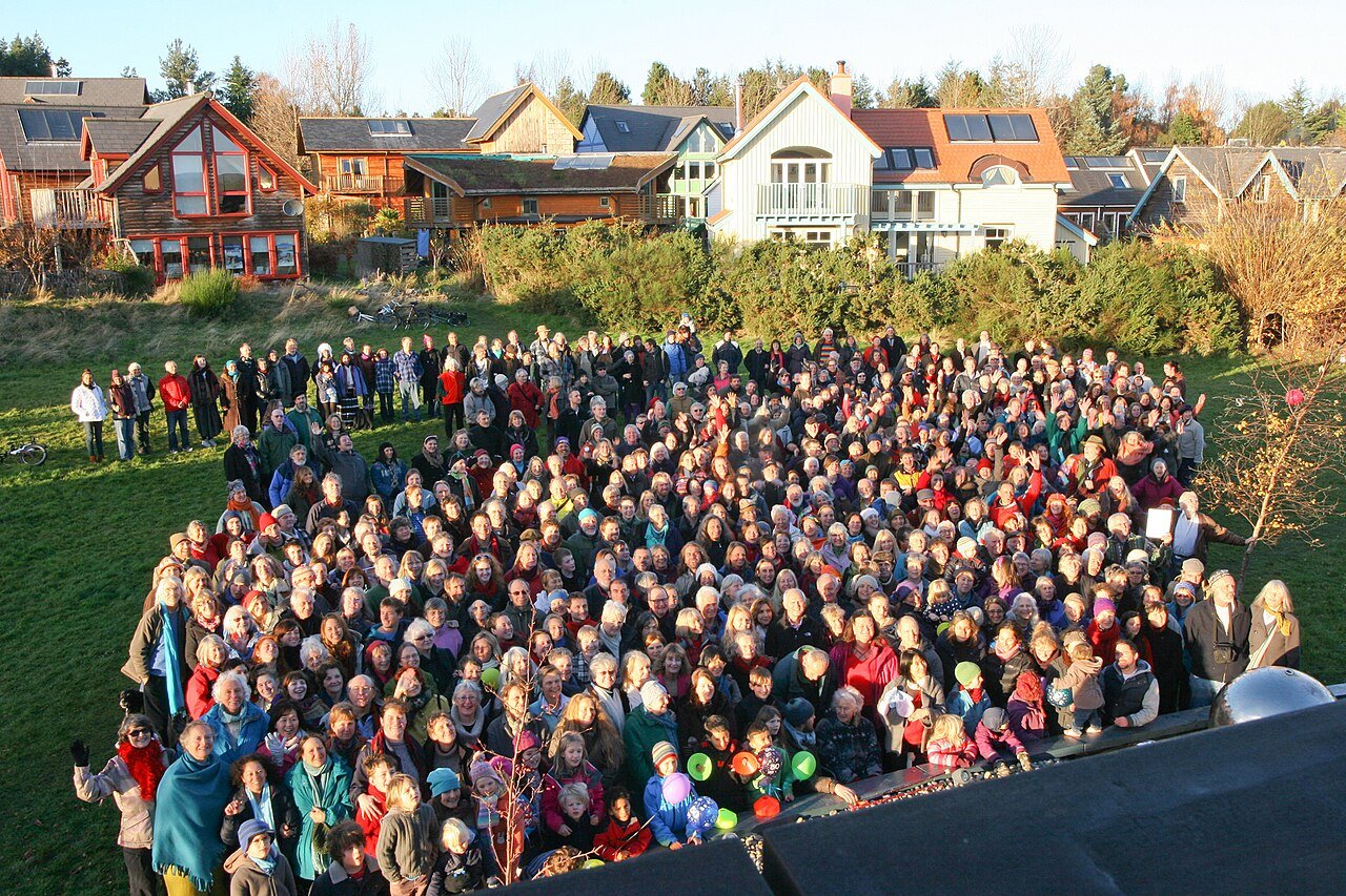 People gathered in front of homes at Findhorn Ecovillage in Scotland.
